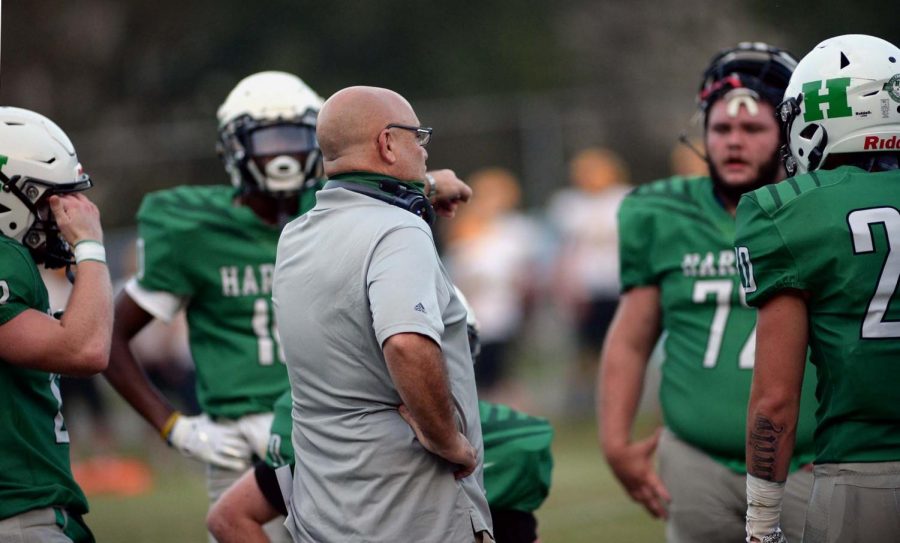 Harlan+coach+Eric+Perry+talked+with+his+team+during+a+game+earlier+this+season.+The+Green+Dragons+earned+their+first+win+with+a+29-18+victory+Friday+at+East+Ridge.
