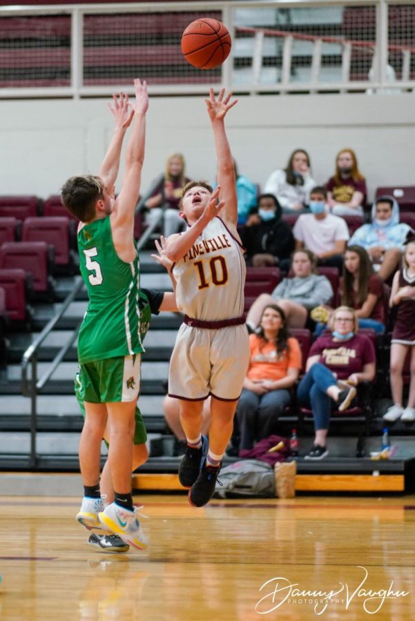 Pinevilles Kadien Robbins shot over Harlans Gage Bailey in seventh- and eighth-grade action Thursday. The Lions won 53-39.