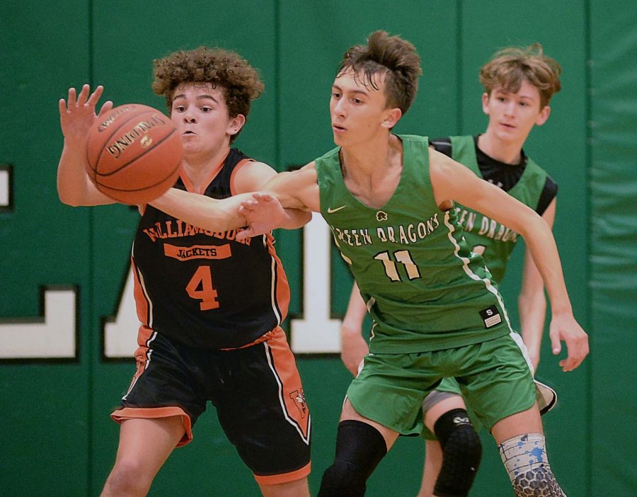 Harlans Dylan Cox and Williamsburgs Andrew Brown went after the ball in middle school basketball action Monday. Williamsburg pulled away in the second half for a 55-37 win.