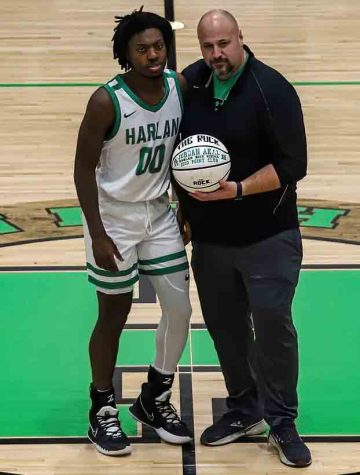 Harlan senior guard Jordan Akal was presented a basketball before a recent game by Harlan High School Principal Britt Lawson in honor of scoring his 2,000th point earlier this season.