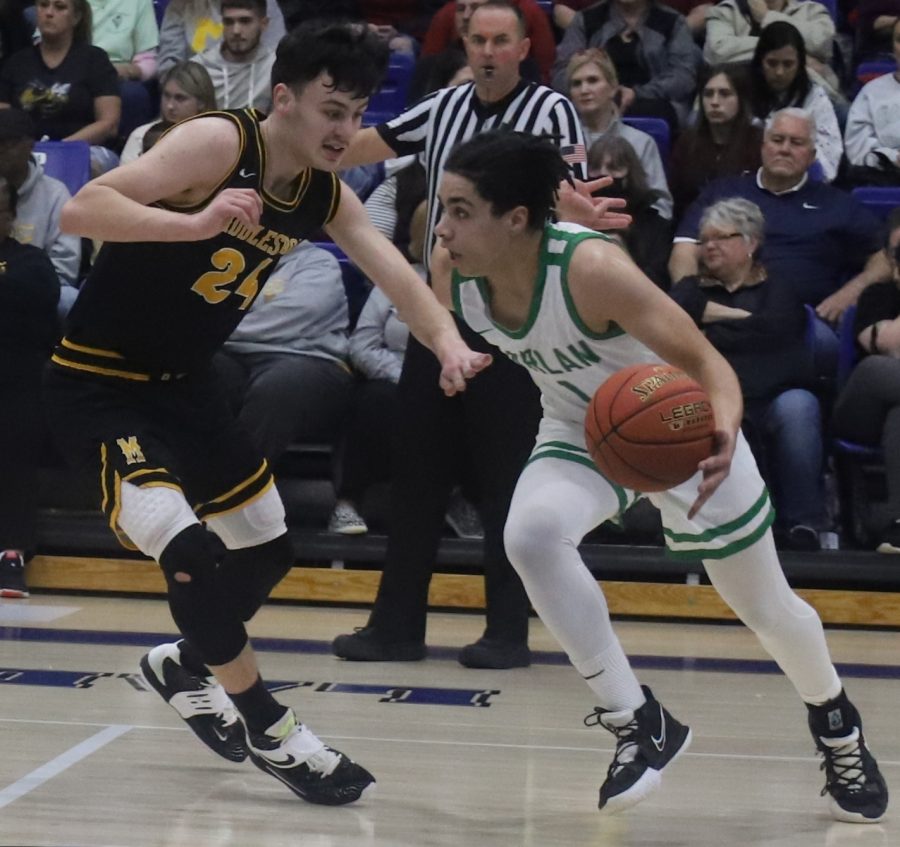Harlan guard Kyler McLendon drove around Middlesboros Braden Ellison in 52nd District Tournament action Tuesday. McLendon poured in 22 points to lead the Dragons to a 75-40 win.