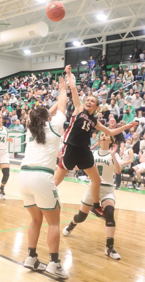 Harlan County guard Ella Karst put up a shot over Harlans Leah Davis in Tuesdays district clash. Karst poured in 26 points to lead HCHS to a 65-53 win.