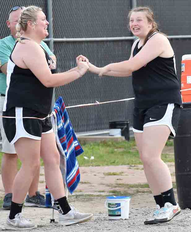 Taylor Lunsford and Lindsey Browning celebrated after finishing second and third, respectively, in the shot put at the Harlan County All-Comers Meet on Friday.