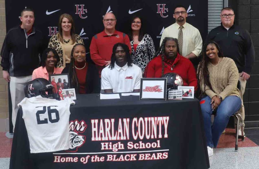 Harlan County High School senior Demarco Hopkins signed with Jacksonville State on Thursday to continue his football career. Joining Hopkins for the signing were his mom, Feliciz Hopkins; father, Perry King; and sisters, Daesha Carr and Dekyia Hopkins. Also shown, standing, from the left, are HCHS athletic director Eugene Farmer, Principal Kathy Napier, HCHS football coach Amos McCreary, Marilyn Williamson, Eddie Creech and Denny Farmer. 