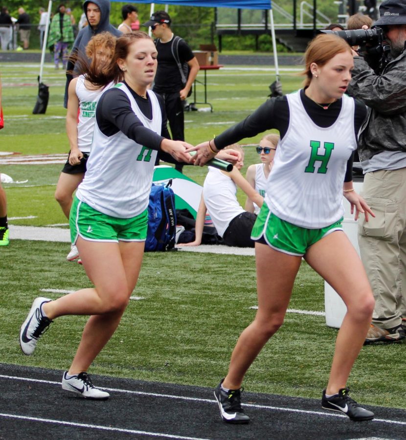 Peighton Jones handed the baton to Abbie Jones as she began the final leg of the 4 x 400 relay on Saturday in the Area 9 meet. Harlan placed second in the race.