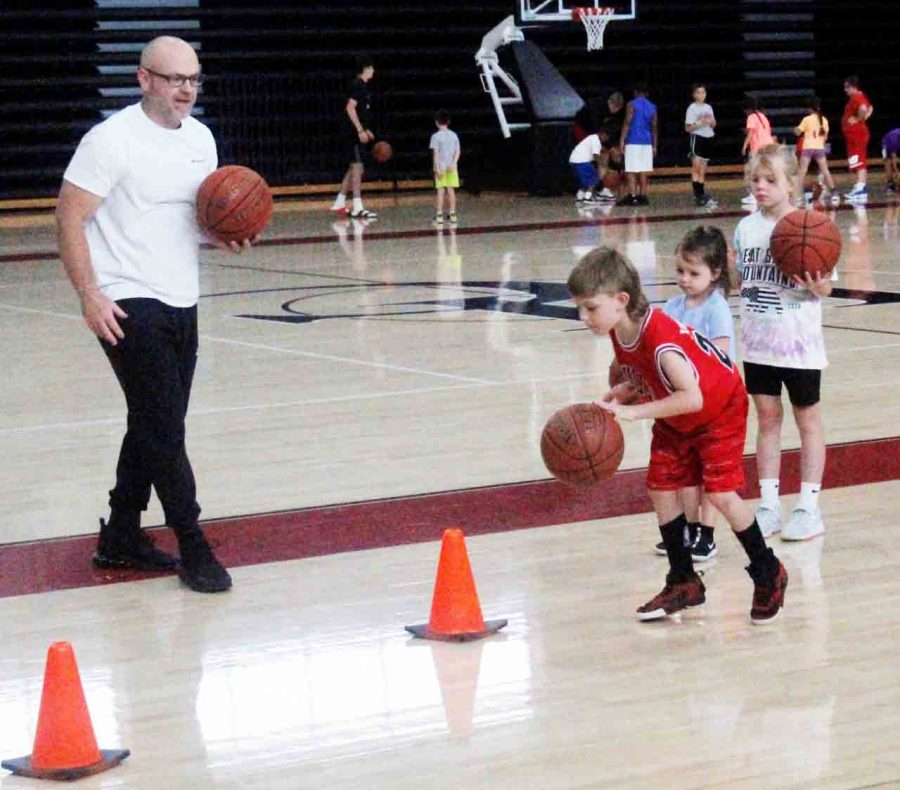 Harlan County coach Kyle Jones worked with campers on a dribbling drill at the Harlan County Black Bears Basketball Camp last week at HCHS. Approximately 60 campers attended the three-day event.