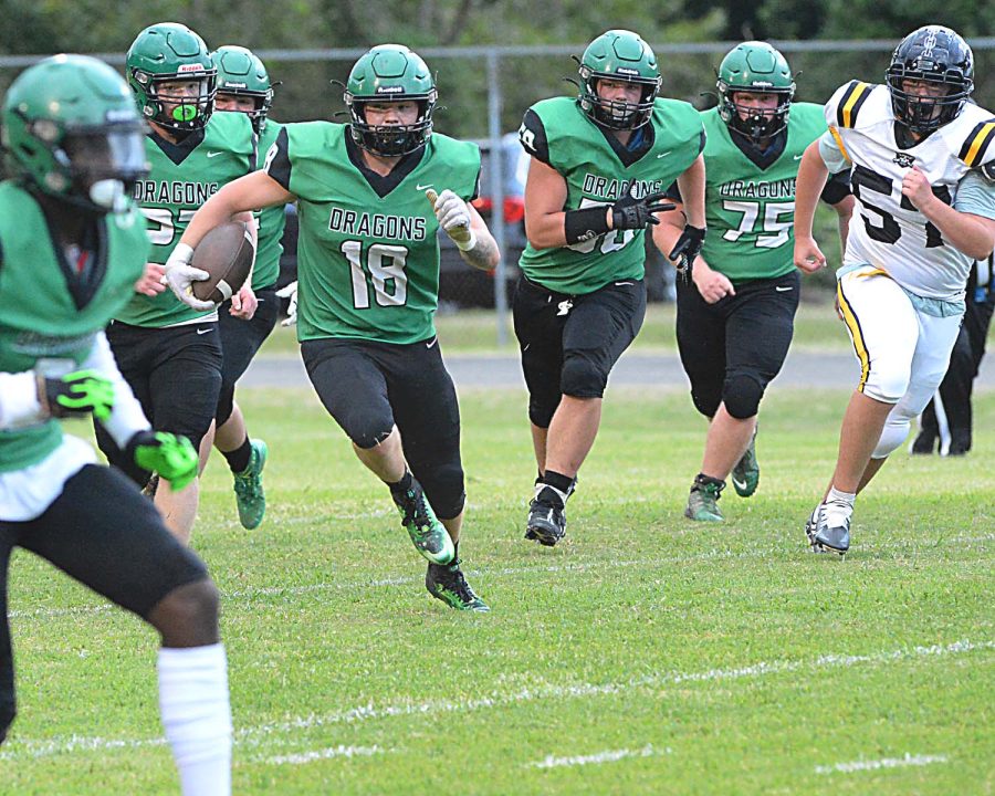 Harlan senior Dylan Middleton was escorted by a big group of Green Dragons for a big gain in a 28-22 season-opening win over Berea in the First Priority Bowl.