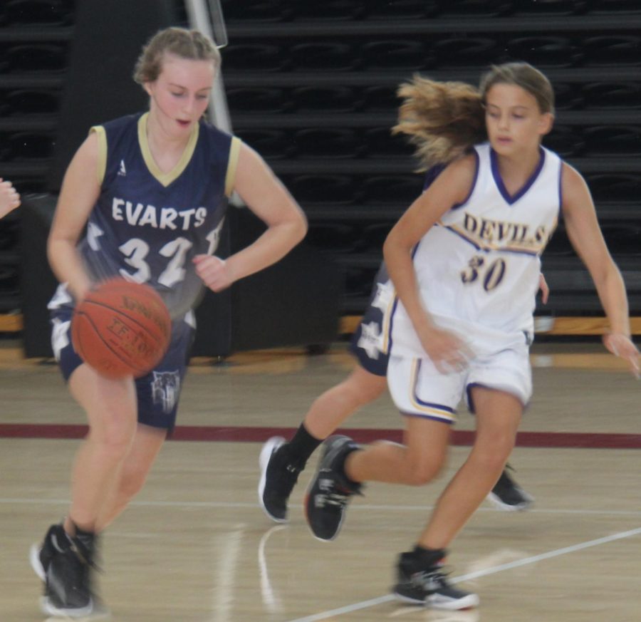 Evarts Rheagan Halcomb headed down the court as Walllins Kylee Runions played defense in action from the Harlan County Preseason Panorama.