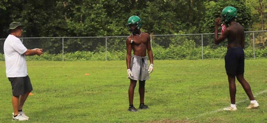Harlan coach Eric Perry worked with Darius Akal and Will Austin in a practice session earlier this summer. The Green Dragons open the season Friday at home against Berea in the First Priority Bowl.