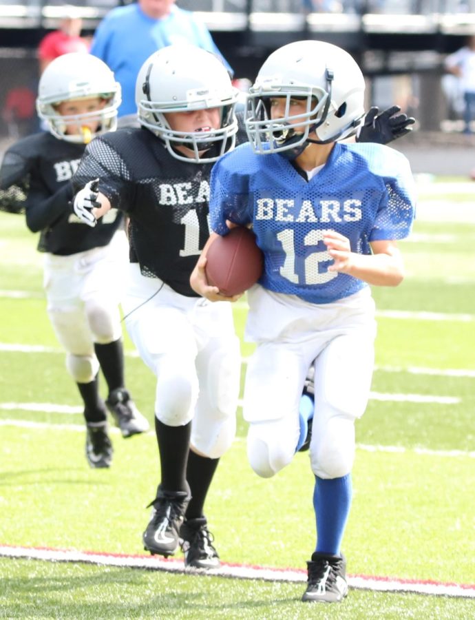 The Harlan County Pee Wee Football League opened Saturday at Coal Miners Memorial Stadium. Sam Carmical, of the Royal Bears, was chased by Bryson Millis, of the Black Bears.