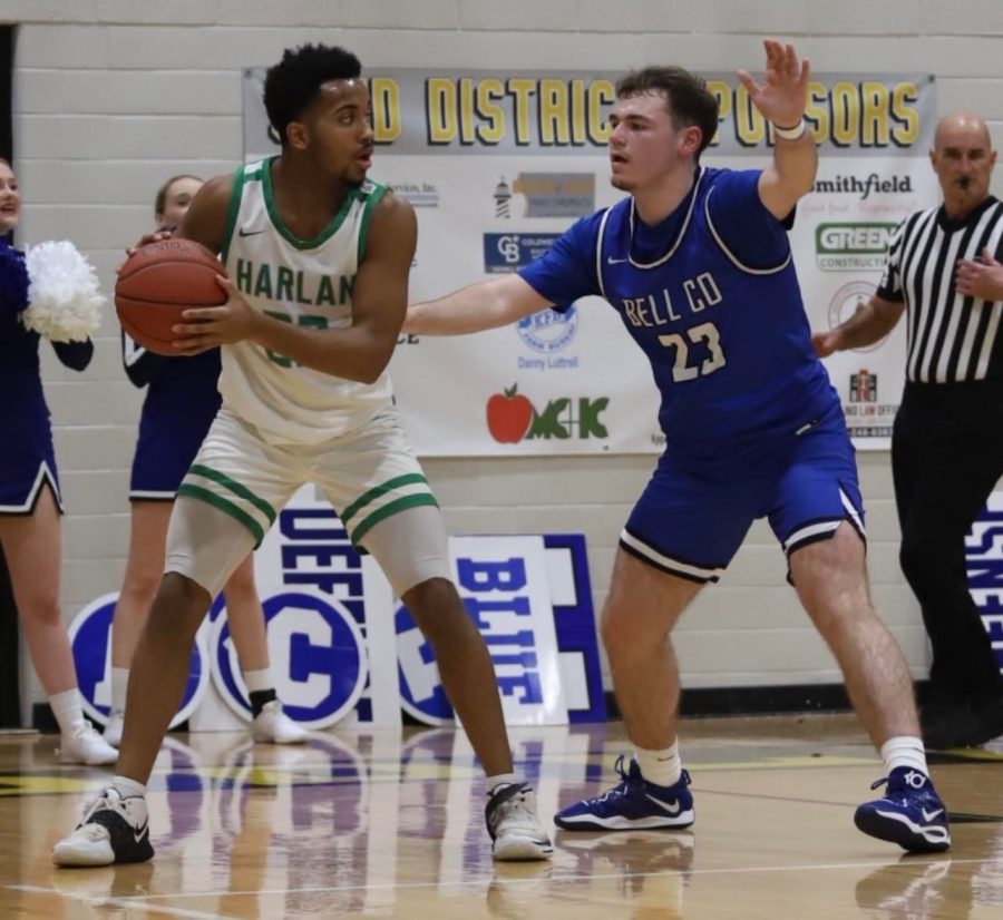 Harlan senior forward Jaedyn GIst looked to pass around Bell Countys Jacob Jones in 52nd District Tournament action. The Green Dragons pulled away down the stretch for a 66-58 victory.