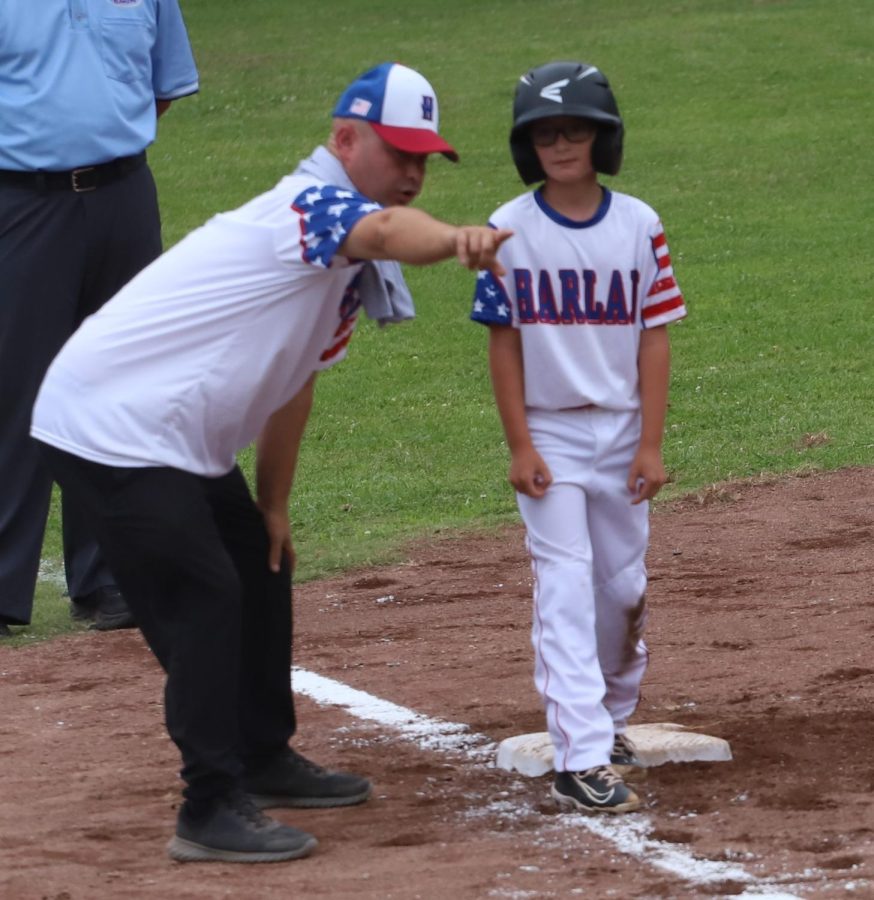 Harlan All-Stars coach Steven Johnson talked with Landen Spurlock after his two-run triple on Friday in the District 4 Tournament. Spurlock drove in four runs on two hits to help Harlan post a 15-1 win.
