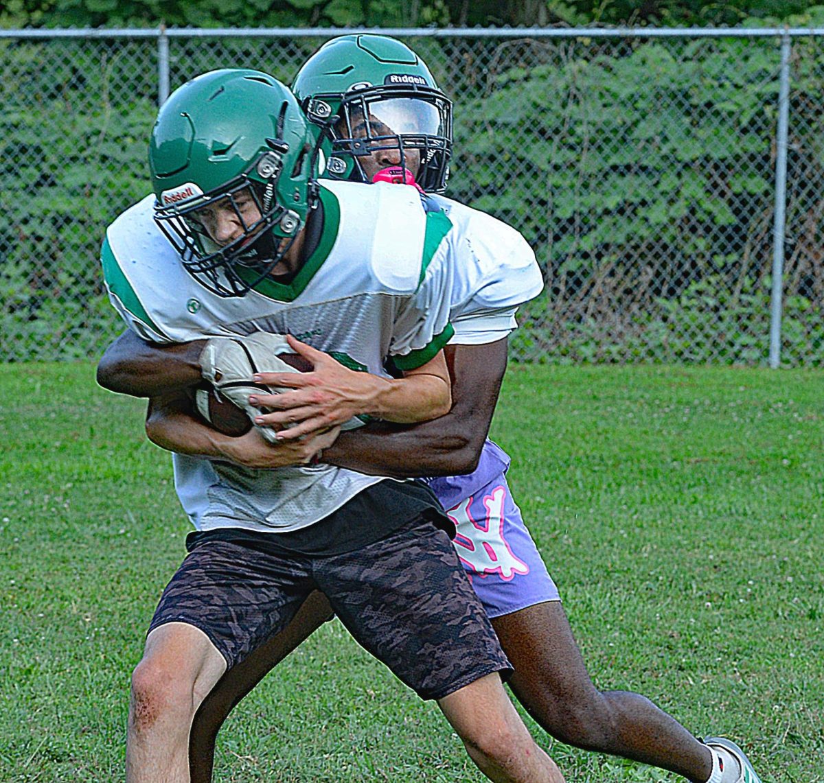 Harlan defensive back Darius Akal wrapped up Charlie Honeycutt during a recent practice session. The Dragons travel to Floyd Central for a scrimmage on Friday and will play host to Twin Springs, Va., in a scrimmage on Aug. 11.