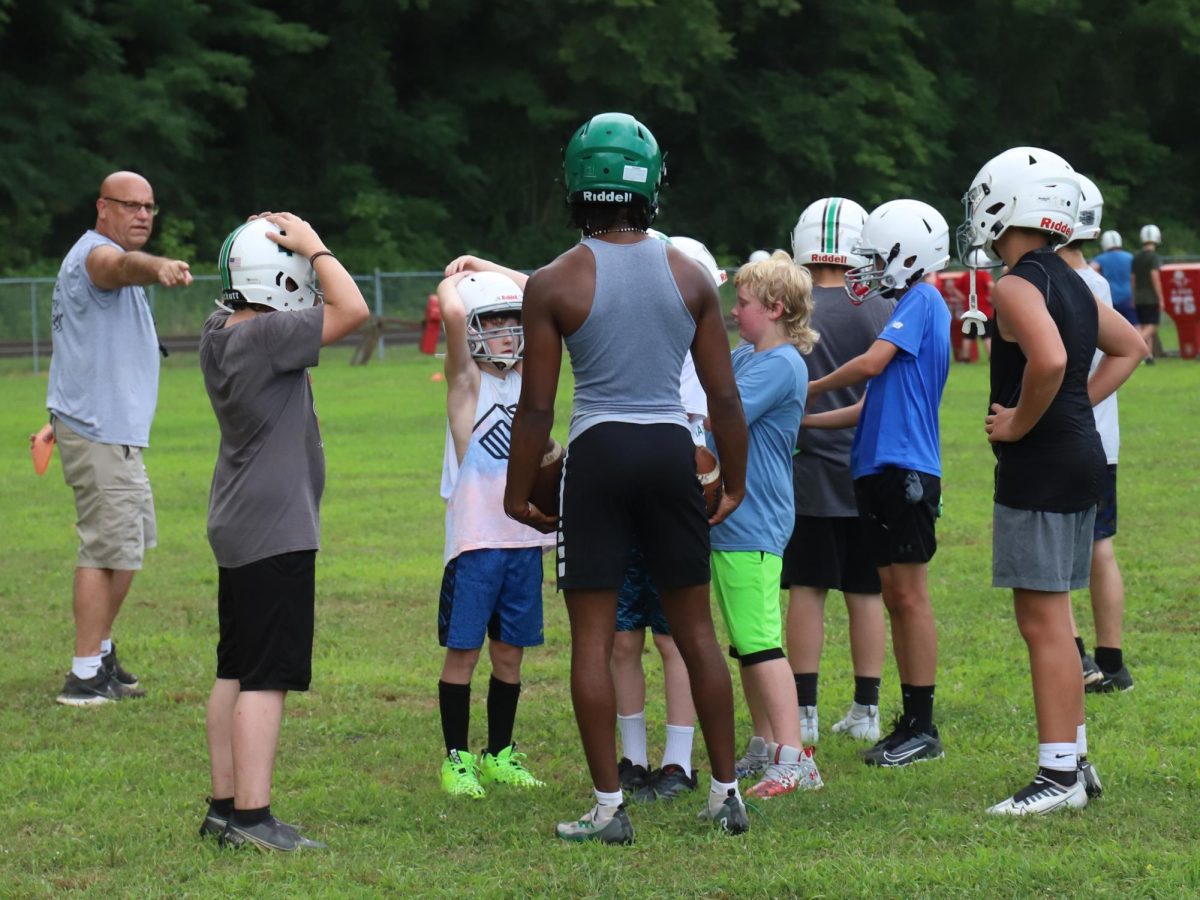 Harlan coach Eric Perry worked with both middle school and high school players during a recent practice session.