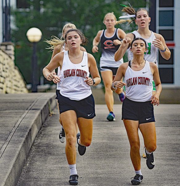 Harlan County runners Addy Gray and Aliyah Deleon headed over a bridge during the Harlan County All-Comers Meet on Tuesday. The Lady Bears won the team title with HCHS junior Peyton Lunsford winning the individual title.