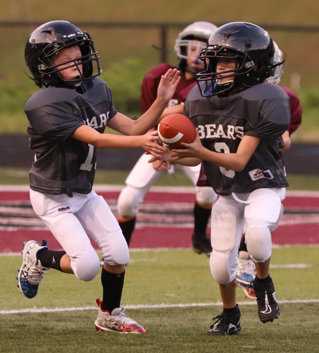 Isaac Combs handed the ball off to Ben Parsons as the Silver Bears were on offense against the Maroon Bears in action Thursday from the Harlan County Pee Wee Football League.