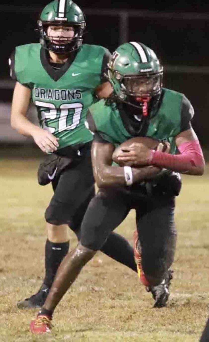 Harlan running back Darius Akal took a handoff from Baylor Varner before picking up yardage in Friday’s game against Williamsburg. Akal ran for 89 yards and a touchdown in the Dragons’ 28-14 loss.