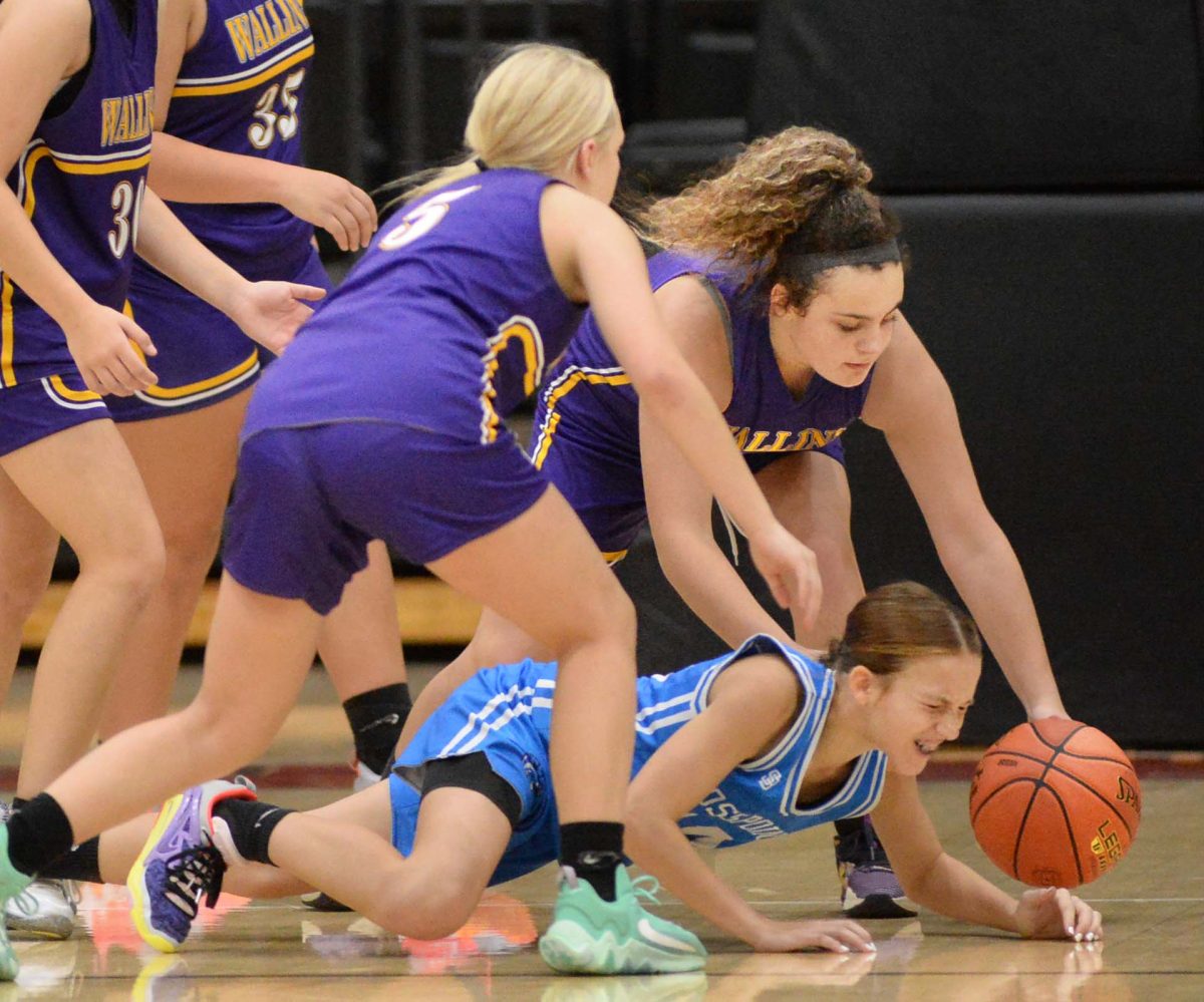 Rosspoint guard Jaycee Simpson went to the floor after a loose ball in Thursdays seventh- and eighth-grade county championship game. Wallins Brooklyn Haywood and Raegan Landa also went after the ball.