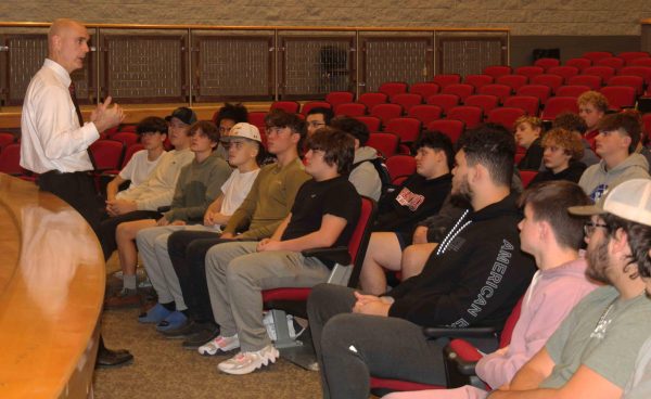 New Harlan County football coach Jacob Saylor talked with his returning players in a meeting Tuesday at the HCHS auditorium.