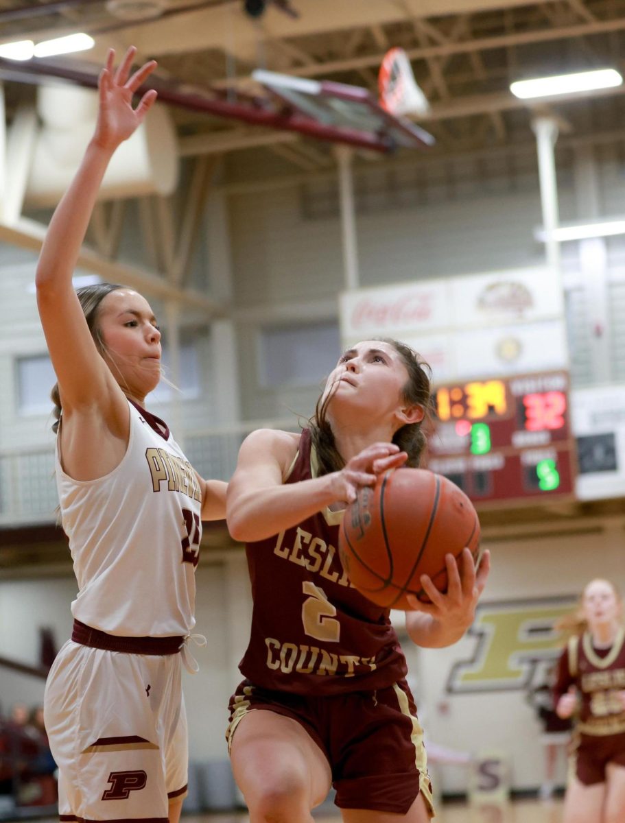 Leslie Countys Iris Napier went to the basket as Pinevilles Kamryn Biliter defended in the season opener for both teams Monday.