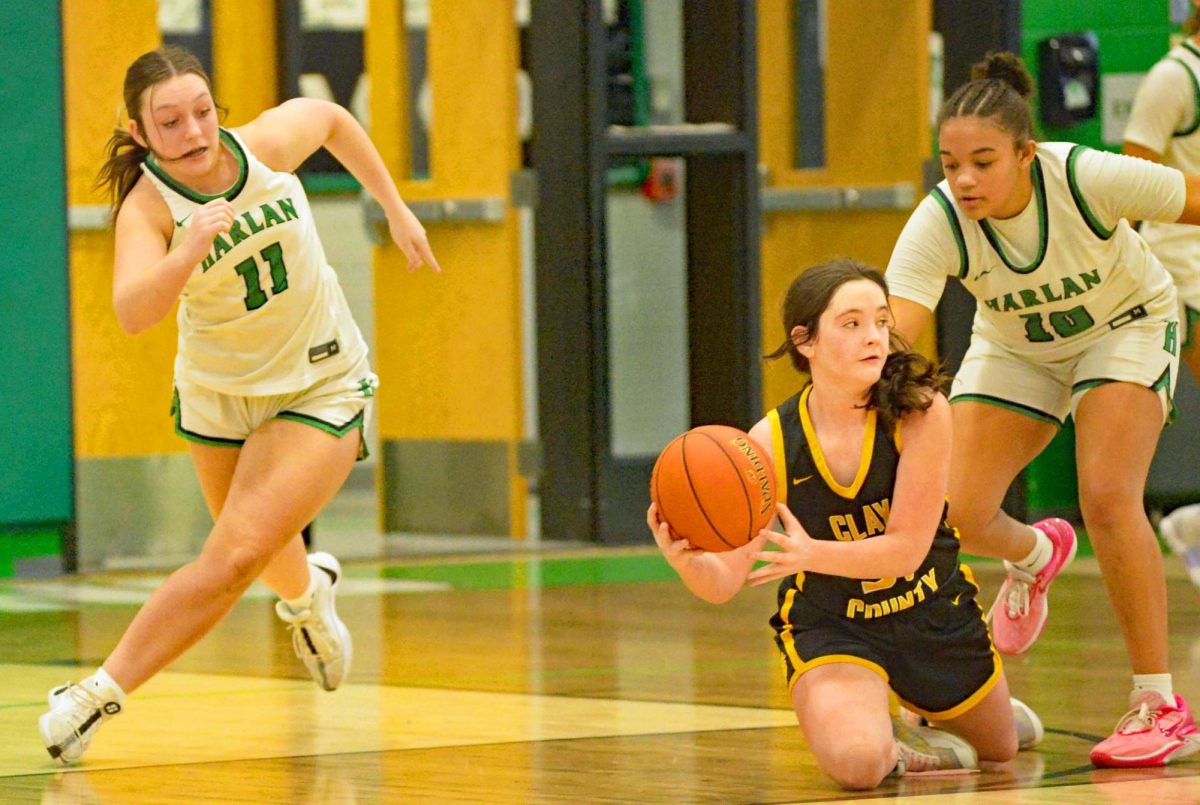 Harlans Addison Campbell (left) and Peyshaunce Wynn moved in as Clay Countys Anna Samples went to the floor for a loose ball in Saturdays game.