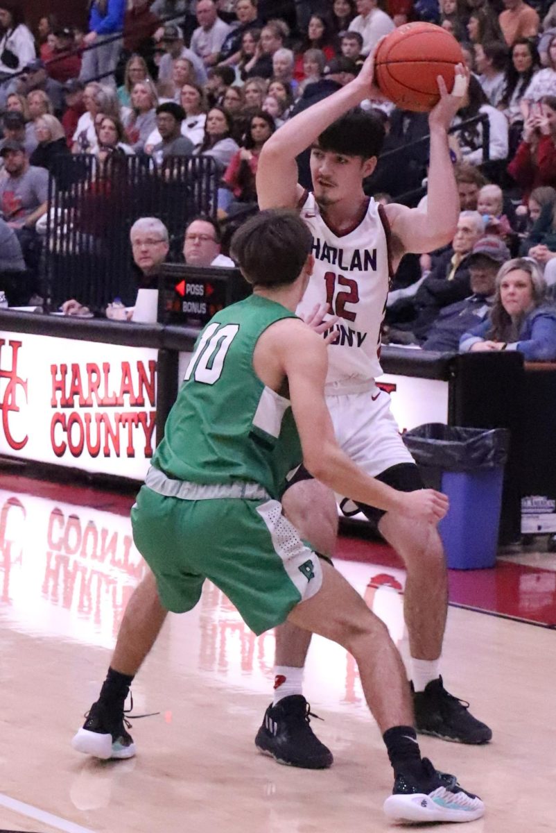 Harlan County forward Caleb Johnson looked for an opening against Harlans Dylan Cox in Mondays district game. Johnson scored 13 points in the Bears win.