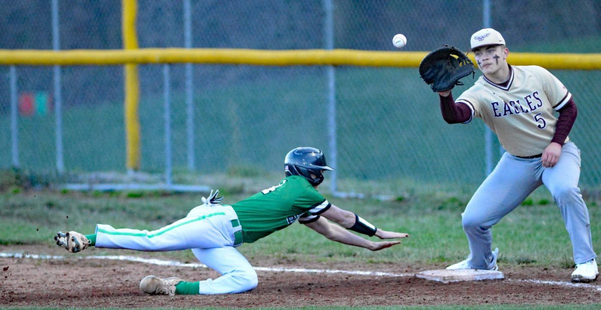 Harlans Jonah Sharp went back to first base during Mondays season-opening game against Leslie County. The Dragons scored three runs in the seventh inning to win 5-4.