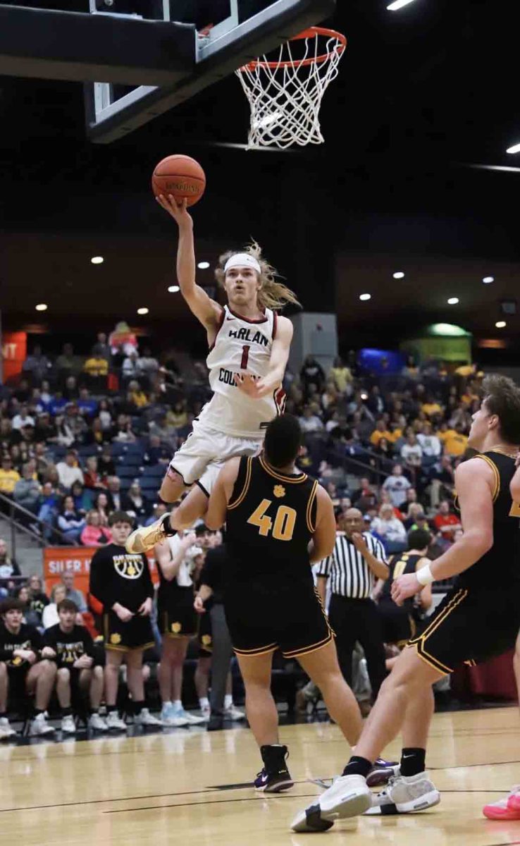 Harlan County guard Reggie Cottrell went over Clay County center Aiden Wagers for a shot in action from the 13th Region Tournament on Saturday. The Bears advanced with a 66-60 victory.