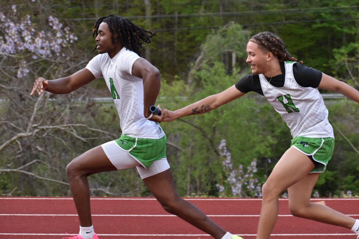 Harlan's Darius Akal took the baton from Tayquan VIck in a relay race earlier this season.