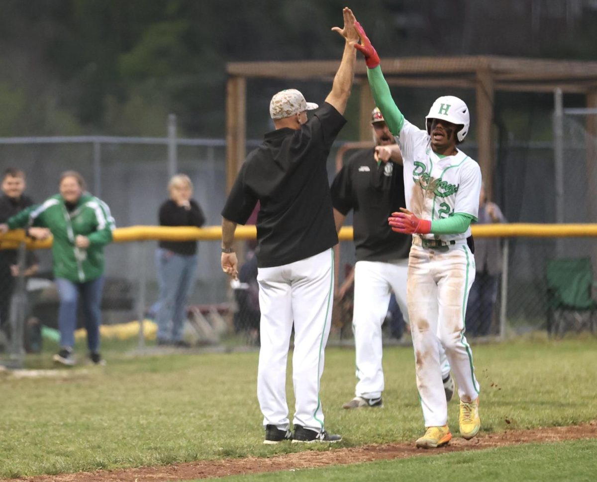 Harlan+second+baseman+Donovan+Montanaro+was+congratulated+after+his+game-winning+three-run+homer+on+Wednesday.+The+Green+Dragons+split+their+two-game+series+against+HCHS+with+a+5-4+victory.