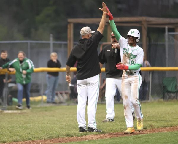 Harlan second baseman Donovan Montanaro was congratulated after his game-winning three-run homer on Wednesday. The Green Dragons split their two-game series against HCHS with a 5-4 victory.