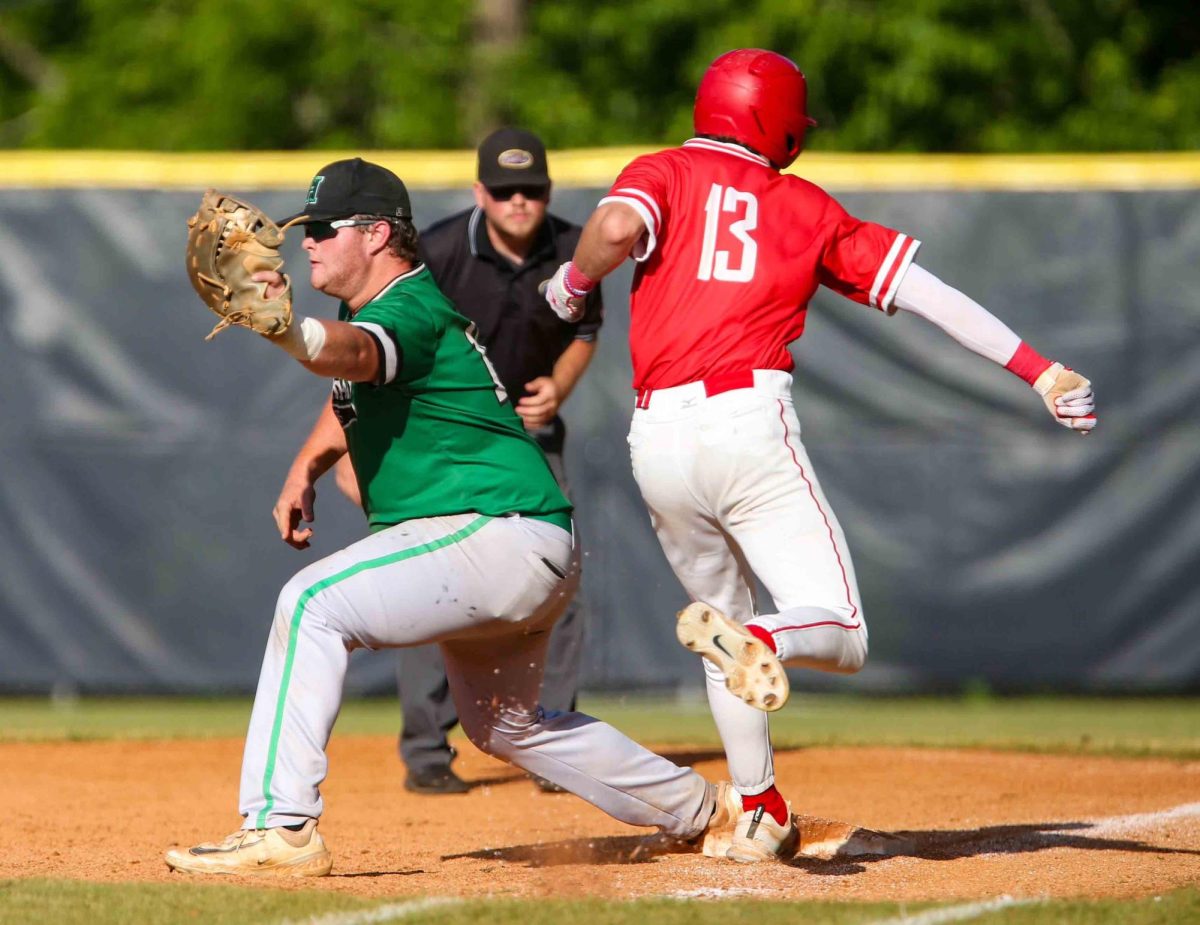 Harlan first baseman Jared Moore took the throw as Corbins Noah Cima stepped on the bag in regional tournament action. Both Moore and Cima hit home runs in the game.
