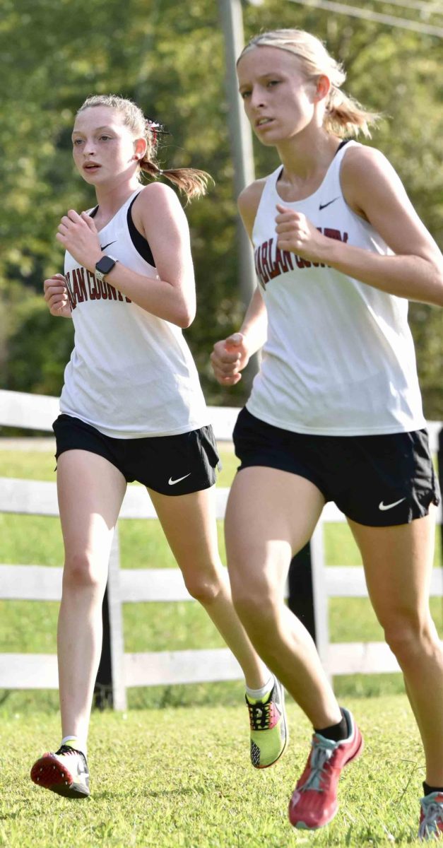 Kiera Roberts (left) and Peyton Lunsford helped the Harlan County Lady Bears capture the team title in the girls division at the HCHS race on Tuesday.