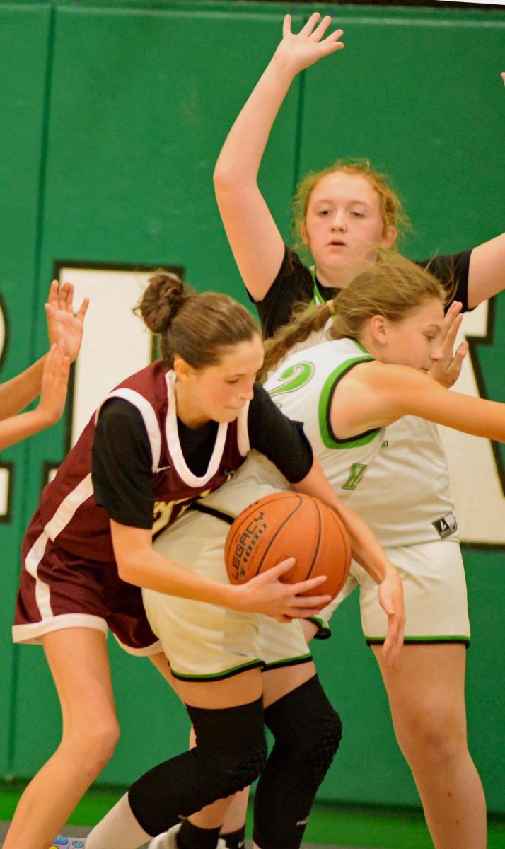 Pineville's Whitney Miracle and Harlan's Bella Lemarr battled for the ball in middle school basketball action Thursday.