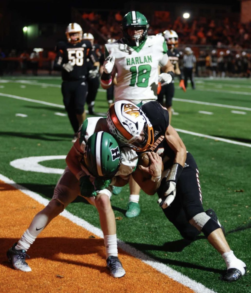 Williamsburg quarterback Nate Goodin went in for a touchdown against Harlan's Jonah Sharp in district action Friday.