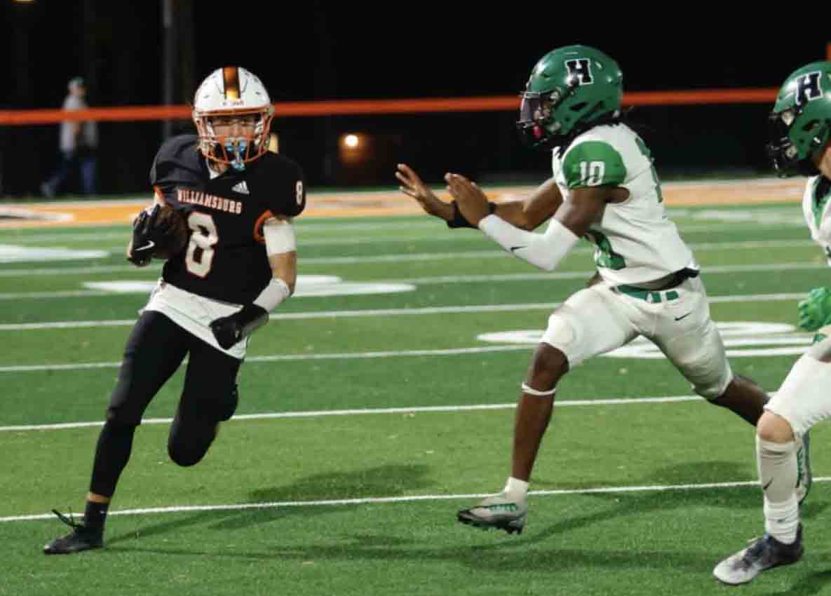 Williamsburg's Chase Meddles picked up yardage as Harlan's Darius Akal moved in for a stop in District 7 action Friday. Williamsburg clinched the district title with a 38-0 victory.