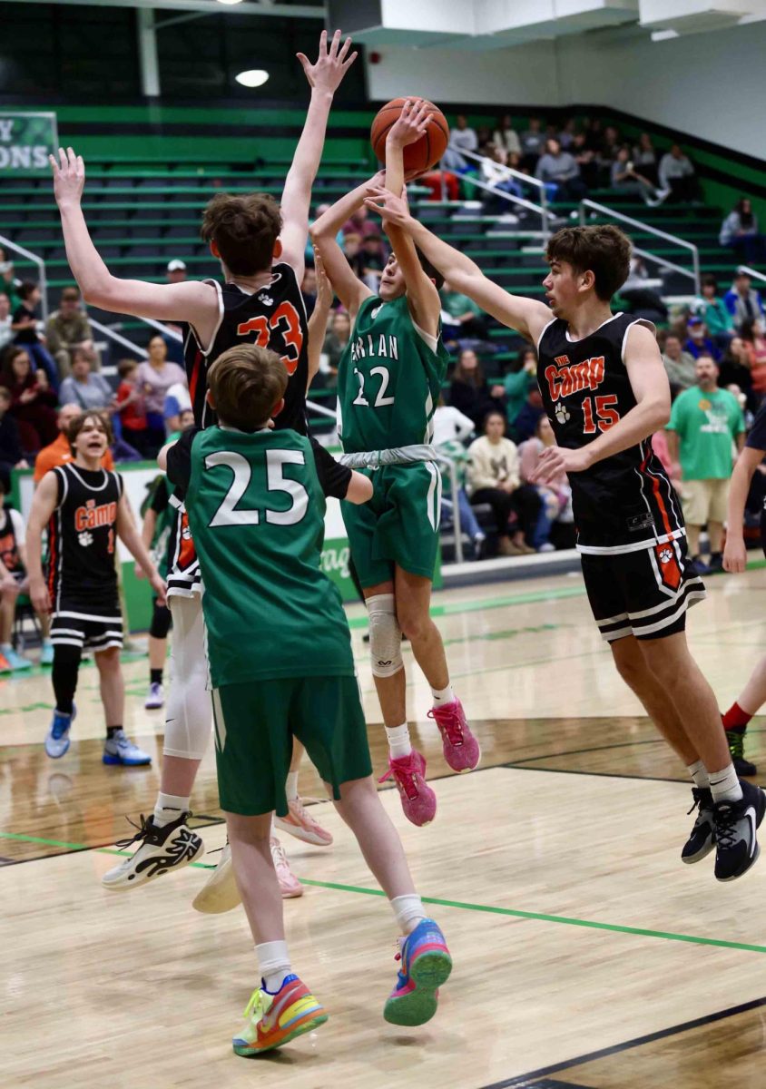 Harlan guard Cooper Thomas put up a shot over Lynn Camp's Donovan Allen in middle school basketball action Thursday. Allen scored 16 points in the Wildcats' 42-27 victory.