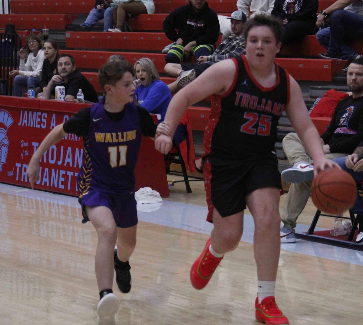 James A. Cawood's Adrian Fields drove against Wallins' Jayden Sargent in middle school basketball action Tuesday.