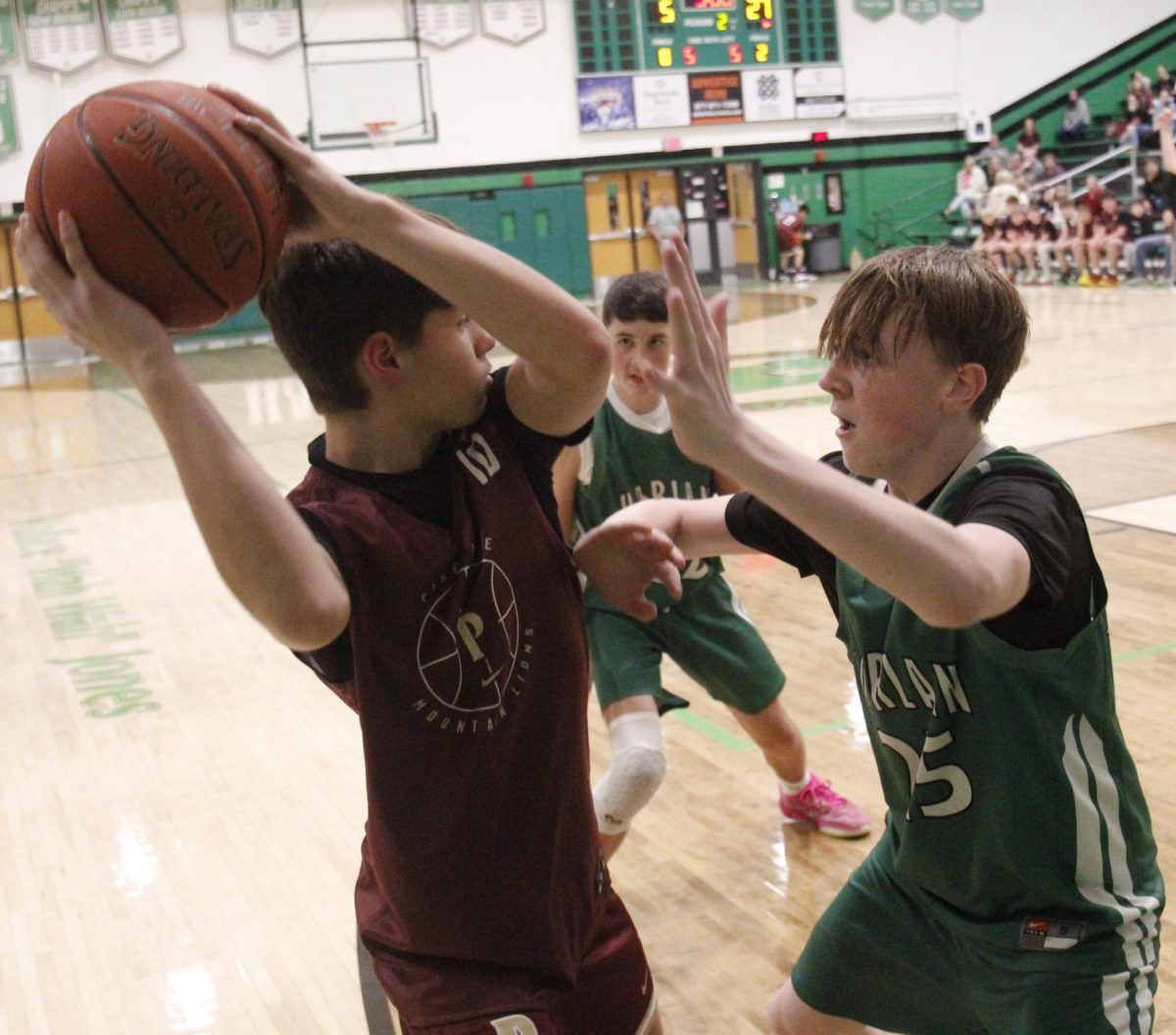 Pineville's Braxton Baker looked to pass around Harlan's Brayden Clark in middle school basketball action Monday.