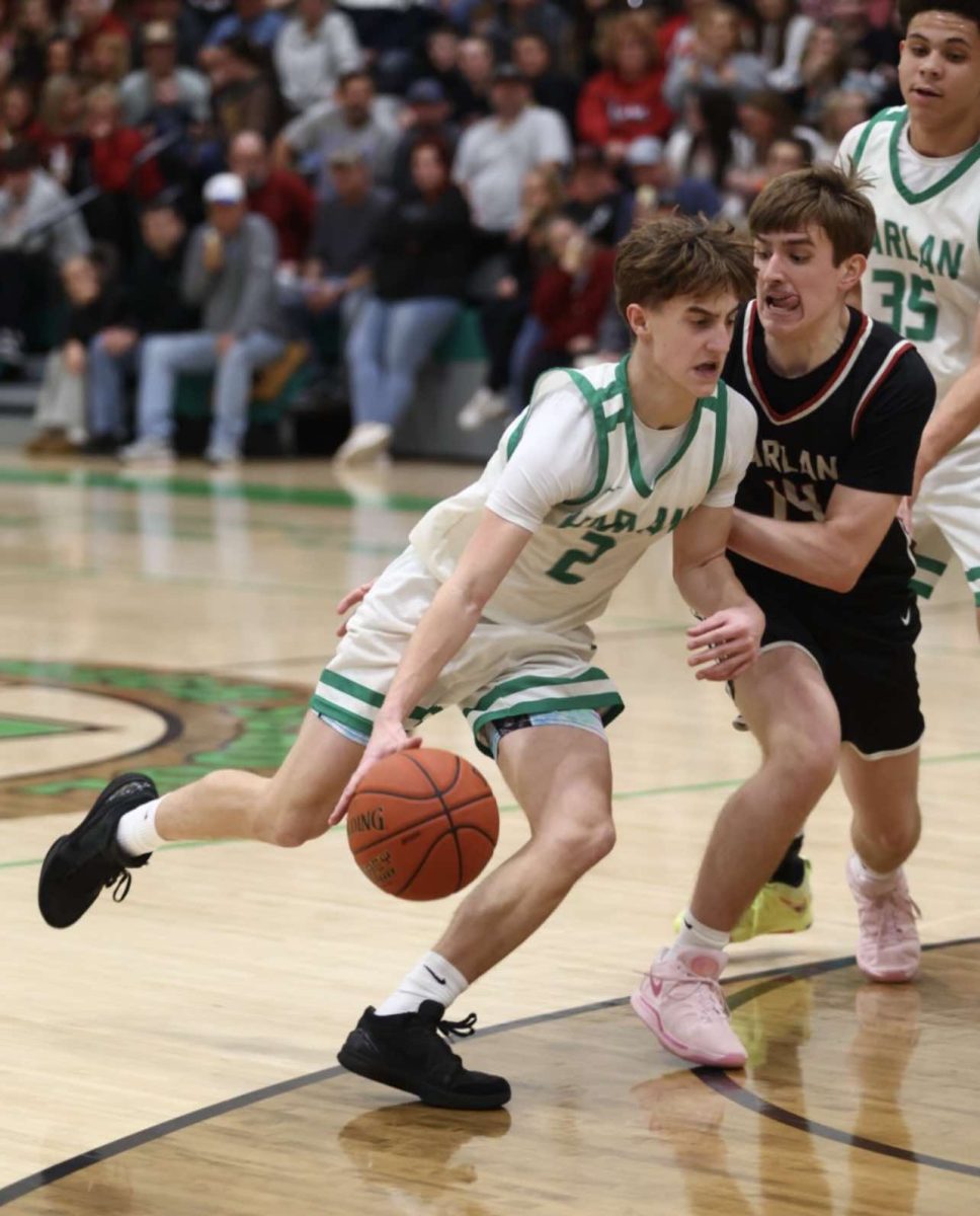 Harlan freshman guard Jaxson Perry worked to the basket against Harlan County's Brody Napier in Thursday's game. Perry led the Dragons with 17 points in a 75-47 loss.