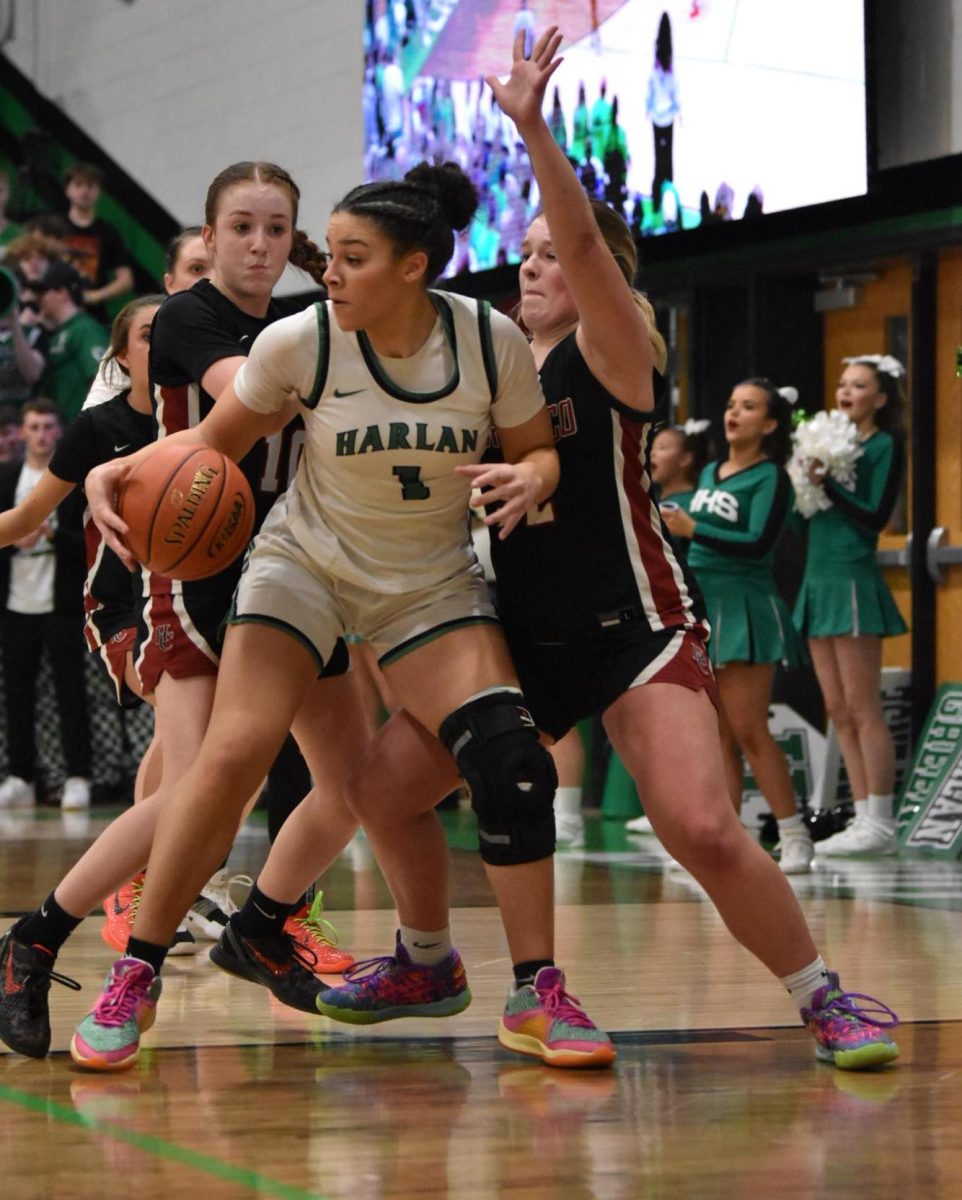 Harlan senior forward Kylie Noe was doubled teamed by Harlan County's Jaycee Simpson and Lacey Robinson in action from the 52nd District Tournament finals on Thursday. Noe scored 25 points in the Lady Dragons' 55-47 victory.