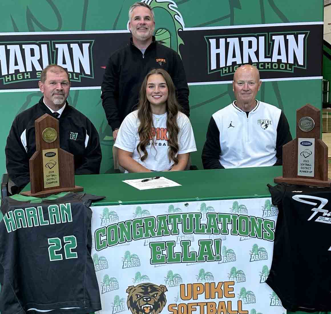 Harlan senior third baseman Ella Lisenbee signed with the University of Pikeville on Monday. She is pictured with Harlan coach David Overbay (left) and University of Pikeville coach Robert Staggs, as well as her father, Scott Lisenbee (standing), an assistant coach at Harlan.