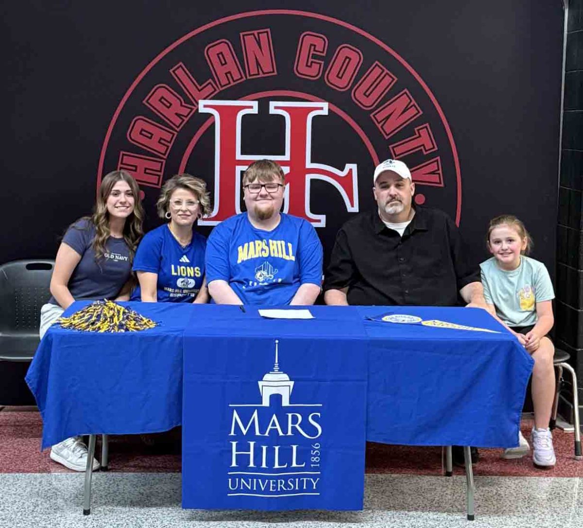 Harlan County High School senior Hunter Lawson became the first county student to sign with a college for esports when he signed with Mars Hill (N.C.) on Tuesday. He is pictured with his sister, Ryleigh; mom, April; father, Mark; and sister, Macie.