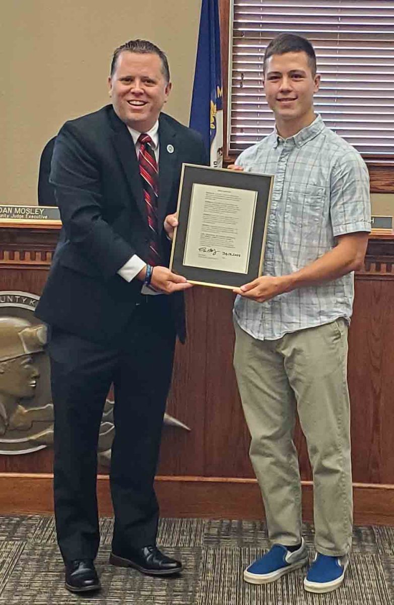 Harlan County Judge-Executive Dan Mosley and Luke Kelly are pictured with the proclamation declaring Friday as Luke Kelly Day in Harlan County for his two state track titles.