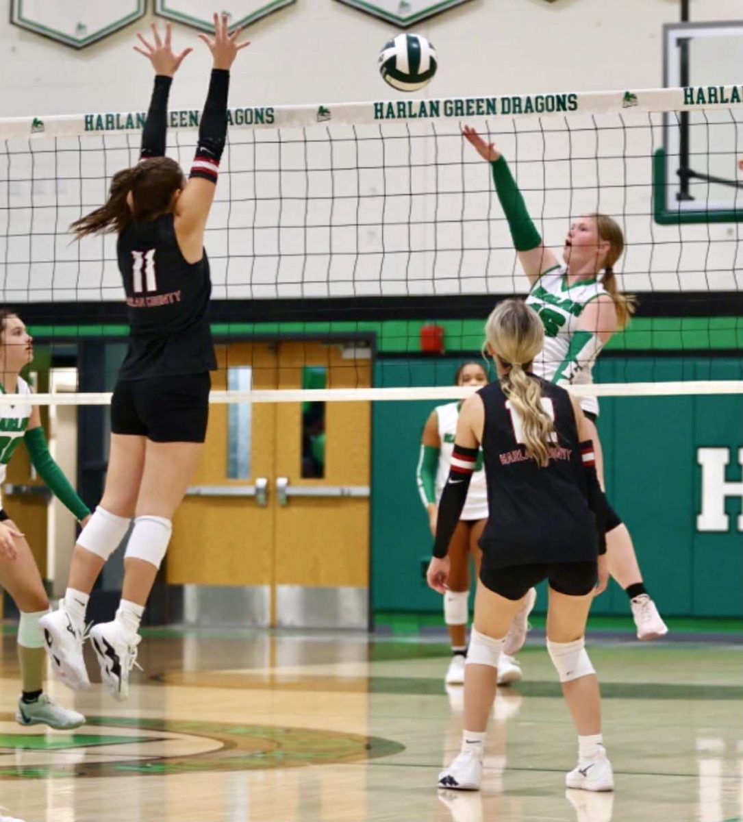 Harlan County senior Kylee Hoiska went up for a block as Harlan's Cheyenne Childers returned the ball in district action Thursday.