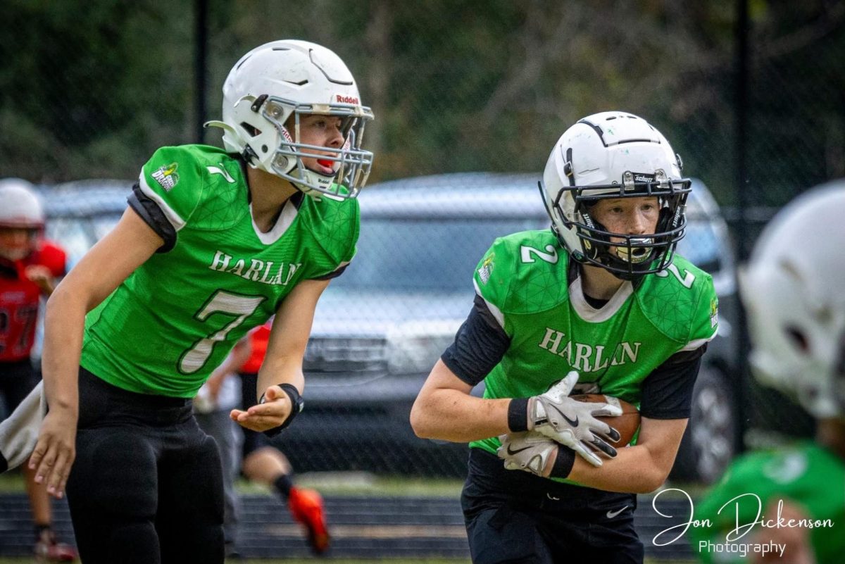 Harlan quarterback Kolbi Green handed the ball off to Rush Luttrell on Saturday during the Dragons' 14-8 win over Perry Central in fifth- and sixth-grade football action at Harlan.