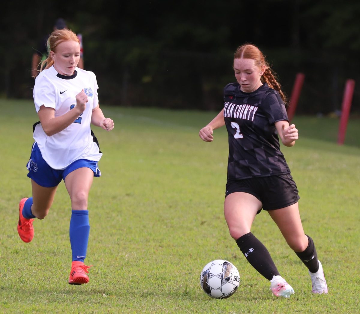 Harlan County sophomore McKenna Dillman advanced down the field as Bell County's Keira Good defended in district soccer action Monday. The visiting Lady Cats claimed an 11-4 victory.