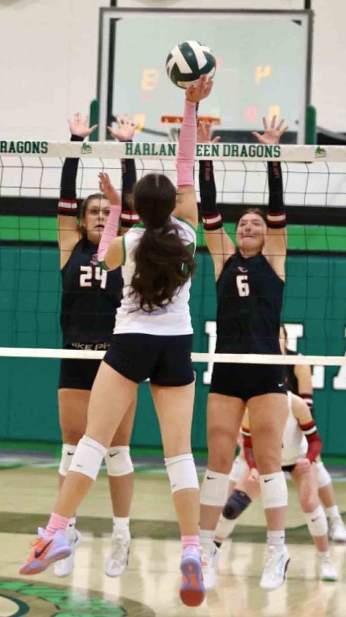Harlan County's Madi Nolan and Kalista Dunn went airborne for a block against Harlan's Clarissa Yost in 52nd District Tournament action Monday. The defending champion Lady Bears advanced with a 25-13, 25-13, 25-6 victory.