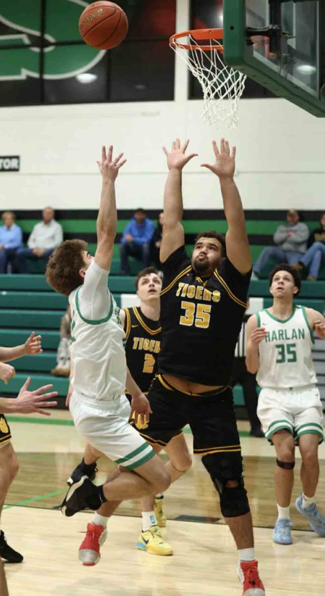 Harlan guard Ethan Huff put up a shot over Clay County's Aiden Wagers in Thursday's game. Wagers scored 21 points, grabbed seven rebounds and played a strong game on defense to lead the Tigers to a 61-49 win.