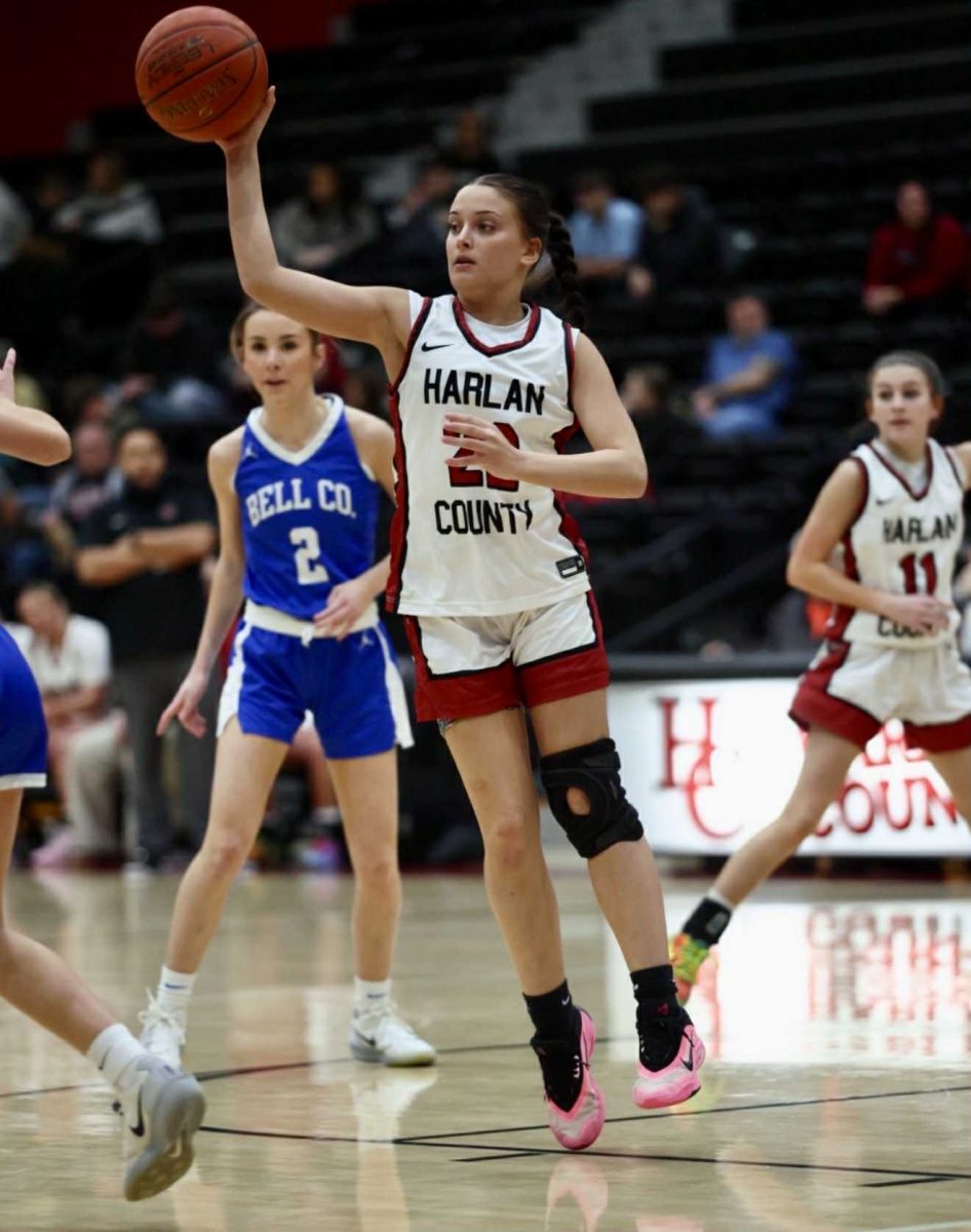 Harlan County sophomore Kylee Runions passed the ball during Wednesday’s district game against visiting Bell County. The Lady Cats stayed perfect in district action with a 60-42 victory.